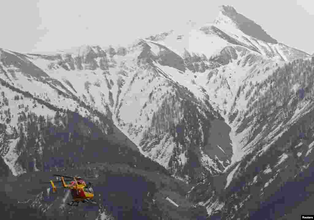 A rescue helicopter from the French Securite Civile flies toward the French Alps during a rescue operation near the crash site of an Airbus A320, near Seyne-les-Alpes, March 24, 2015.